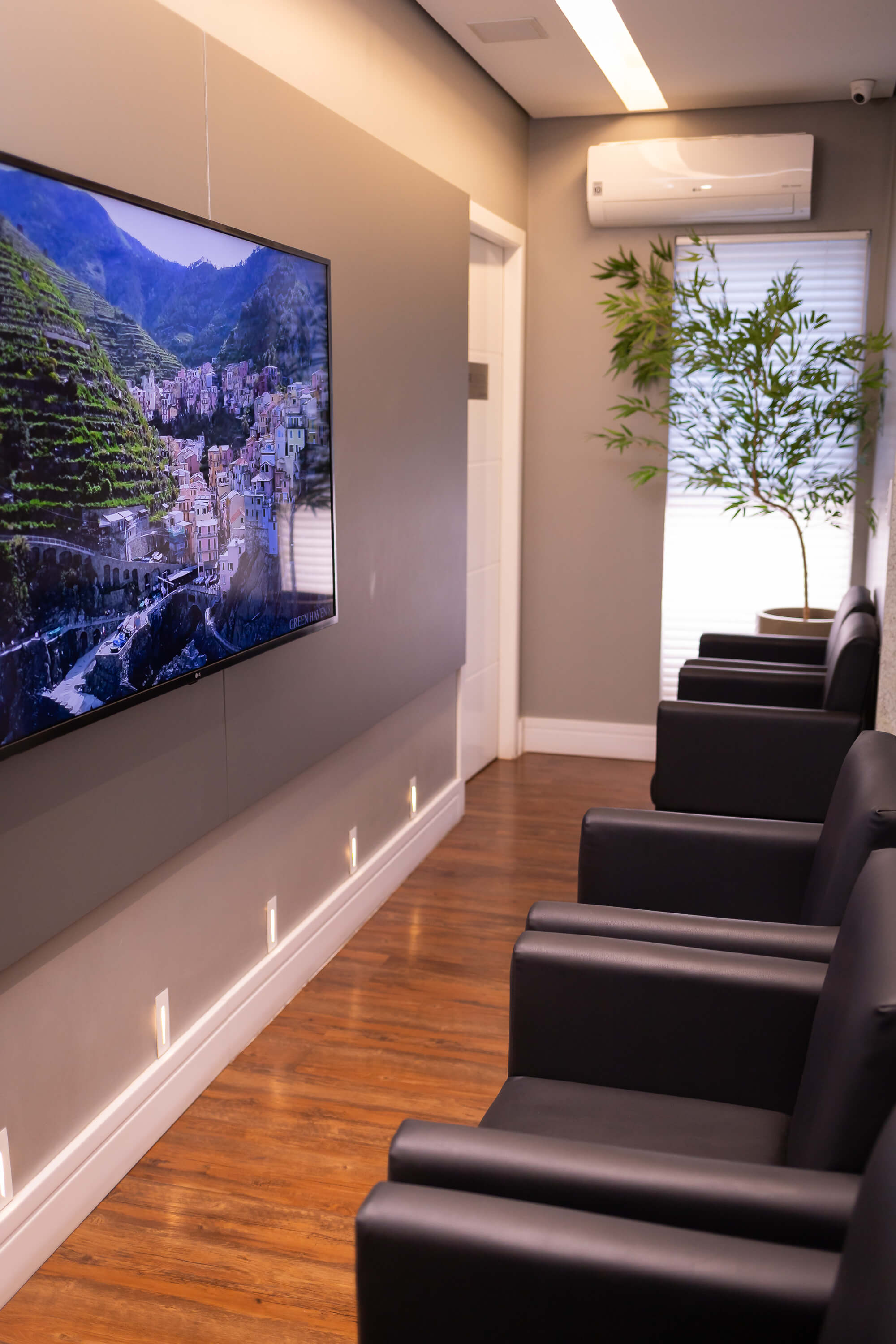 Sala de espera confortável com TV e poltronas